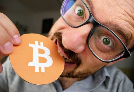 Naslovna slika videa, na kateri je Jože, ki z zobmi grize v kartonast simbol za Bitcoin