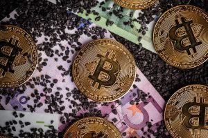 Stock fotografija kriptovalute Bitcoina na evrskih bankovcih.