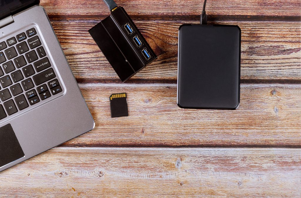 Fotografija laptopa, čitalca USB kartic, kartice in zunanjega diska